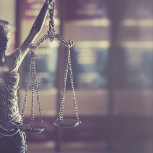 shutterstock_justice_holding_scales_with_law_books