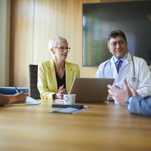 Doctors and lawyers speaking at a table.
