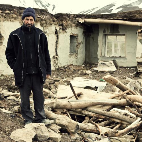 Man standing next to destroyed home.