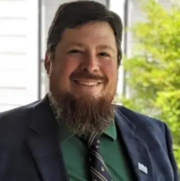 Headshot of man smiling in a suit jacket