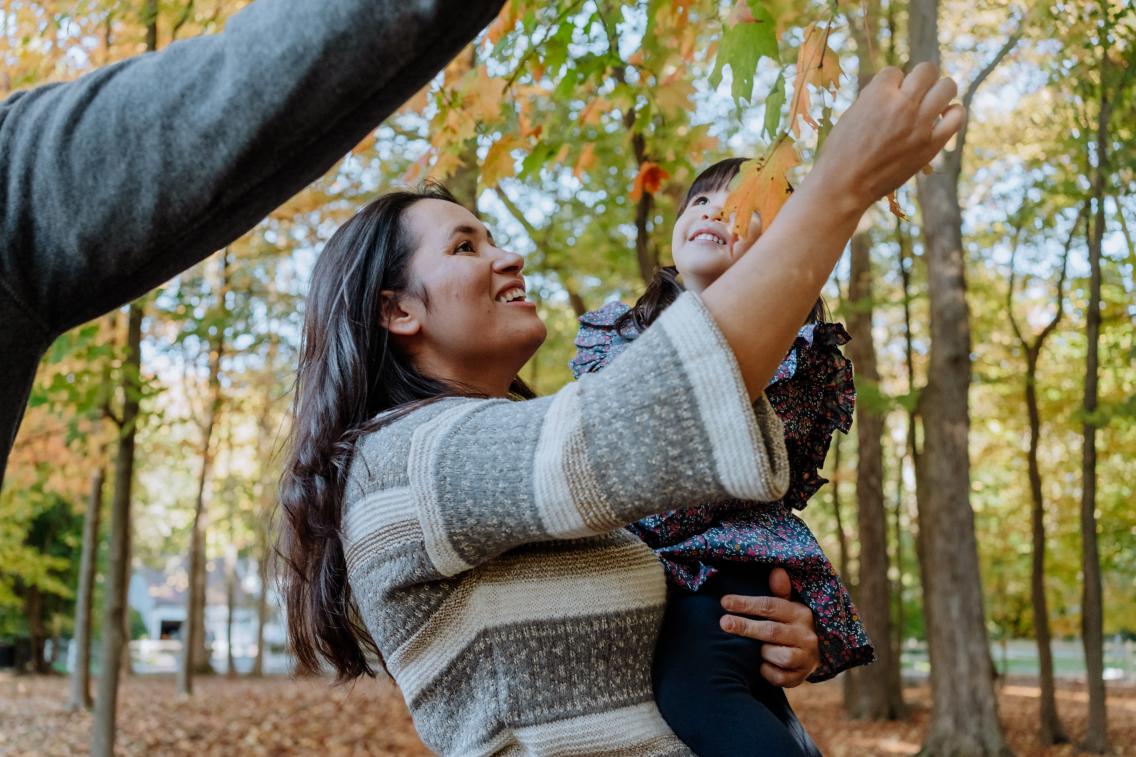 mother holding son in a forest